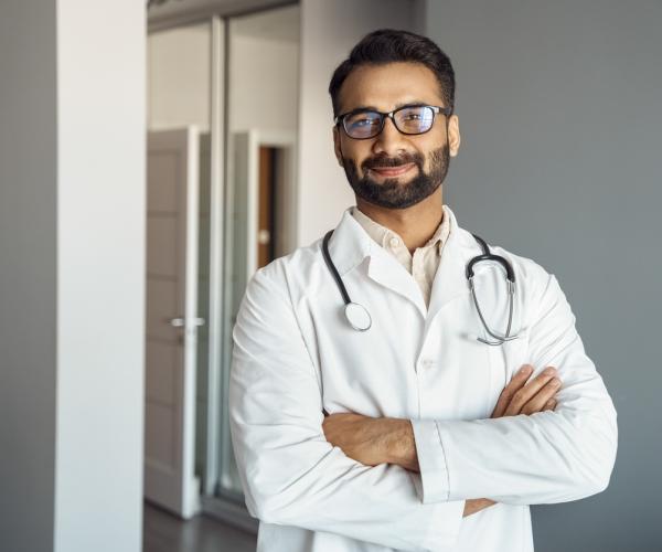 Doctor smiling with crossed arms.