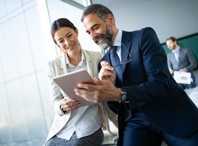 Two businesspeople looking at tablet